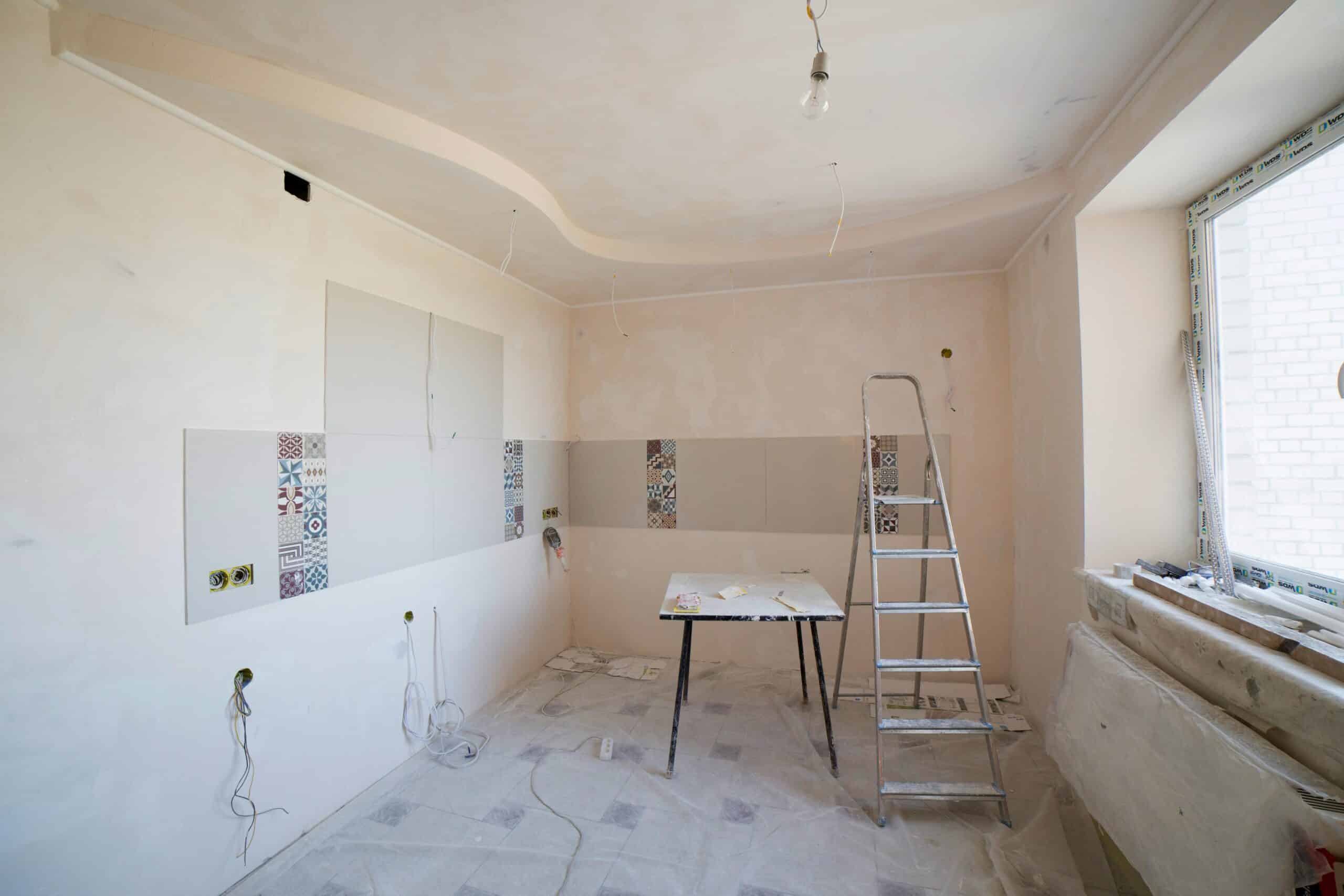 optimiser le Potentiel de votre intérieur. 3 Spacious kitchen under renovation with ladder and tools, showcasing a fresh new design.